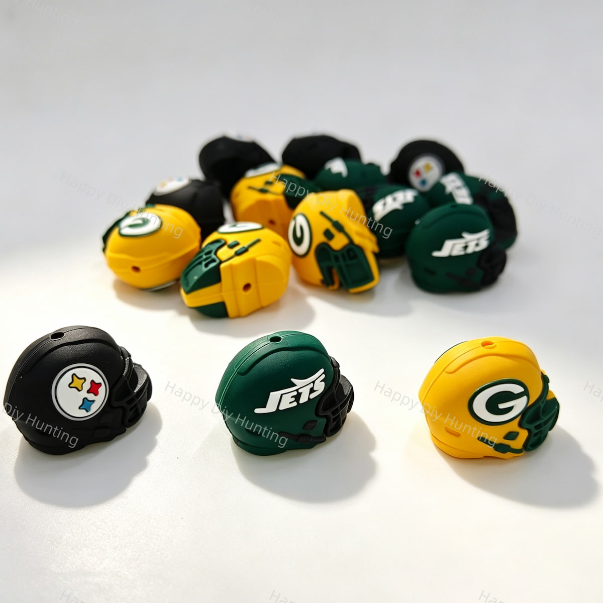 Close-up of mixed color 3D football helmet silicone focal beads, including black, green, and yellow designs. Soft, durable, and flexible, perfect for sports-themed beadable pens, keychains, and handmade crafts.