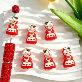 Silicone focal beads featuring a Mrs Claus Christmas grandma character print design. Soft, durable, and flexible, perfect for beadable pens, keychains, and handmade holiday crafts.