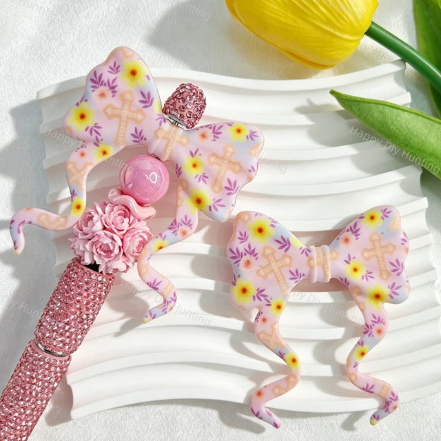 Bow-shaped silicone focal beads featuring a pastel floral and cross print design. Soft, durable, and flexible, perfect for beadable pens, keychains, and handmade crafts.