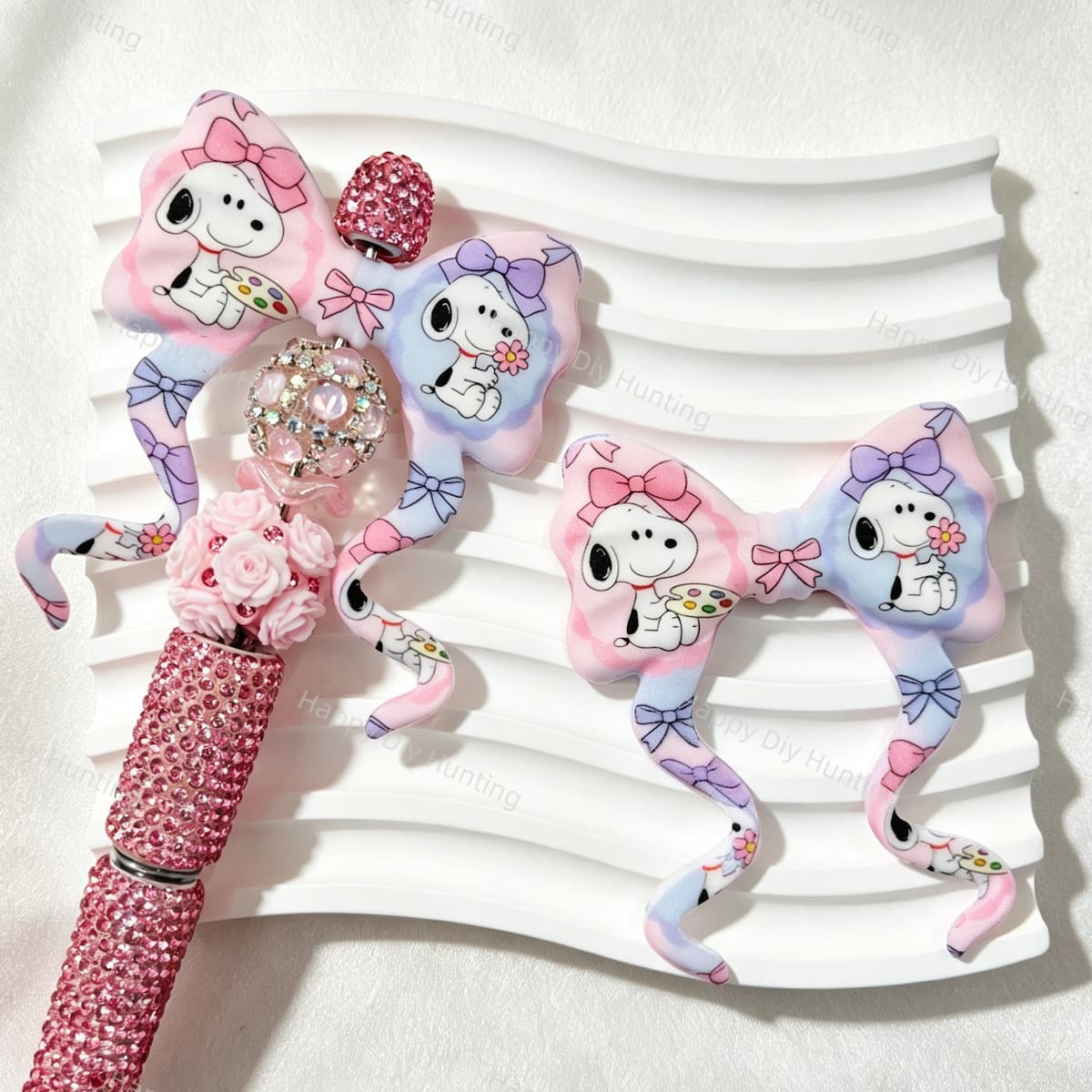 Bow-shaped silicone focal beads featuring a pastel pink and purple cartoon puppy print design. Soft, durable, and flexible, perfect for beadable pens, keychains, and handmade crafts.