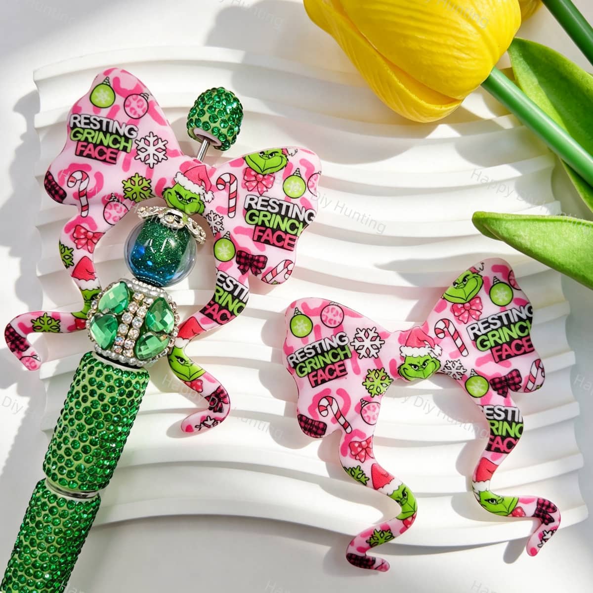 Bow-shaped silicone focal beads featuring a pink camo and Christmas green character print design. Soft, durable, and flexible, perfect for beadable pens, keychains, and handmade holiday crafts.