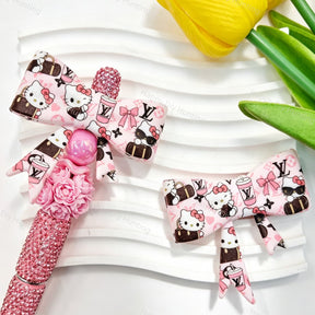Bow-shaped silicone focal beads featuring a pink cartoon kitten and V*L print design. Soft, durable, and flexible, perfect for beadable pens, keychains, and handmade crafts.