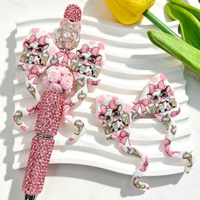 Bow-shaped silicone focal beads featuring a pink cow holding a coffee cup print design. Soft, durable, and flexible, perfect for beadable pens, keychains, and handmade crafts.
