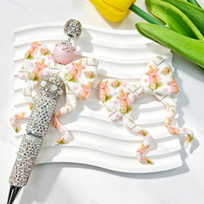 Bow-shaped silicone focal beads featuring a pink floral castle print design. Soft, durable, and flexible, perfect for beadable pens, keychains, and handmade crafts.