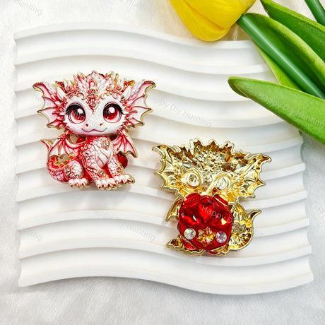 Red and white cute baby dragon metal fancy bead with rhinestones shown from the front and back. The front features a detailed red and white baby dragon with big eyes and rhinestone accents, while the back shows gold metal wings with a red crystal flower center. Perfect for DIY beadable pens and crafts.