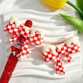 Bow-shaped silicone focal beads featuring a red checkered pattern with a glossy drip cream finish. Soft, durable, and flexible, perfect for beadable pens, keychains, and handmade crafts.