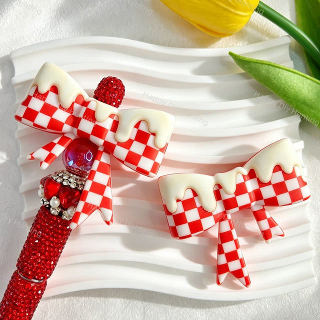 Bow-shaped silicone focal beads featuring a red checkered pattern with a glossy drip cream finish. Soft, durable, and flexible, perfect for beadable pens, keychains, and handmade crafts.