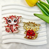 Red cute baby dragon metal fancy bead with rhinestones shown from the front and back. The front features a detailed red and white baby dragon with big eyes and rhinestone accents, while the back shows gold metal wings with a red crystal flower center. Perfect for DIY beadable pens and crafts.