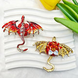 Red flying winged dragon metal fancy bead with rhinestones shown from the front and back. The front features a detailed red dragon with enamel wings and a rhinestone-studded body, while the back shows gold metal wings with a red crystal flower center. Perfect for DIY beadable pens and crafts.