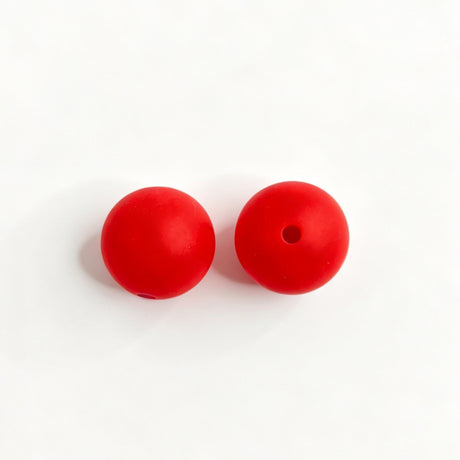 Red round silicone bead shown from two angles, one smooth side and one with a center hole. Soft, durable, and flexible, perfect for beadable pens, keychains, and handmade crafts.