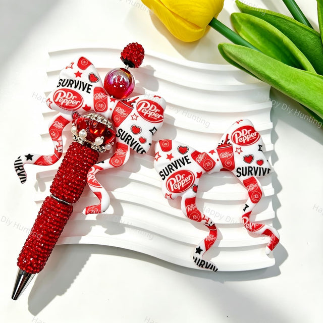 Bow-shaped silicone focal beads featuring a red and white soda brand print design. Soft, durable, and flexible, perfect for beadable pens, keychains, and handmade crafts.