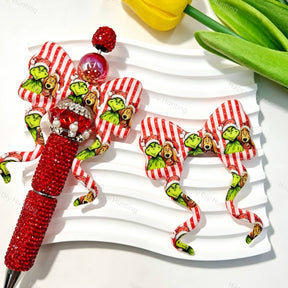 Red striped bow-shaped silicone focal beads featuring a festive Christmas character print design. Soft, durable, and flexible, perfect for beadable pens, keychains, and handmade holiday crafts.