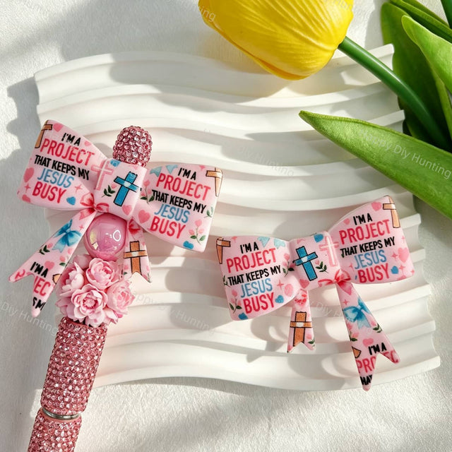Bow-shaped silicone focal beads featuring a religious cross and inspirational quote print design. Soft, durable, and flexible, perfect for beadable pens, keychains, and handmade crafts.