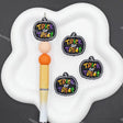 Three pumpkin-shaped 'Trick or Treat' stickers displayed on a white cloud-shaped tray next to a yellow and white pen, set against a dark gray background.