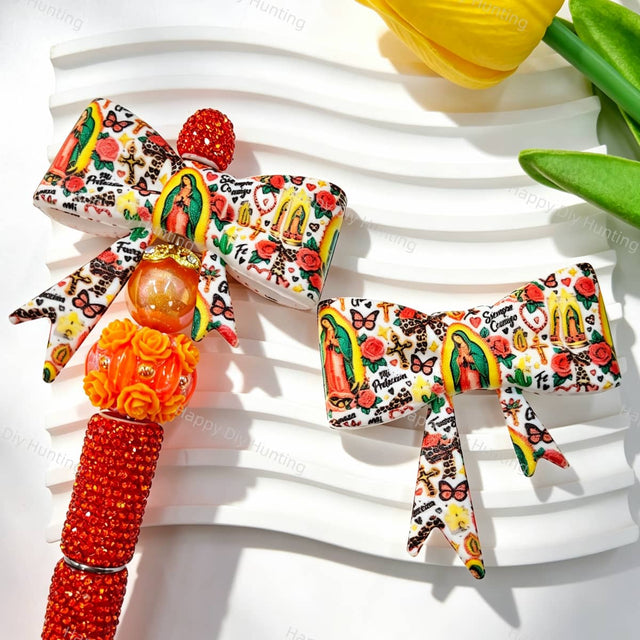 Bow-shaped silicone focal beads featuring a vintage tattoo style religious figure, red roses, cactus, and decorative elements on a white background. Soft, durable, and flexible, perfect for beadable pens, keychains, and handmade crafts.