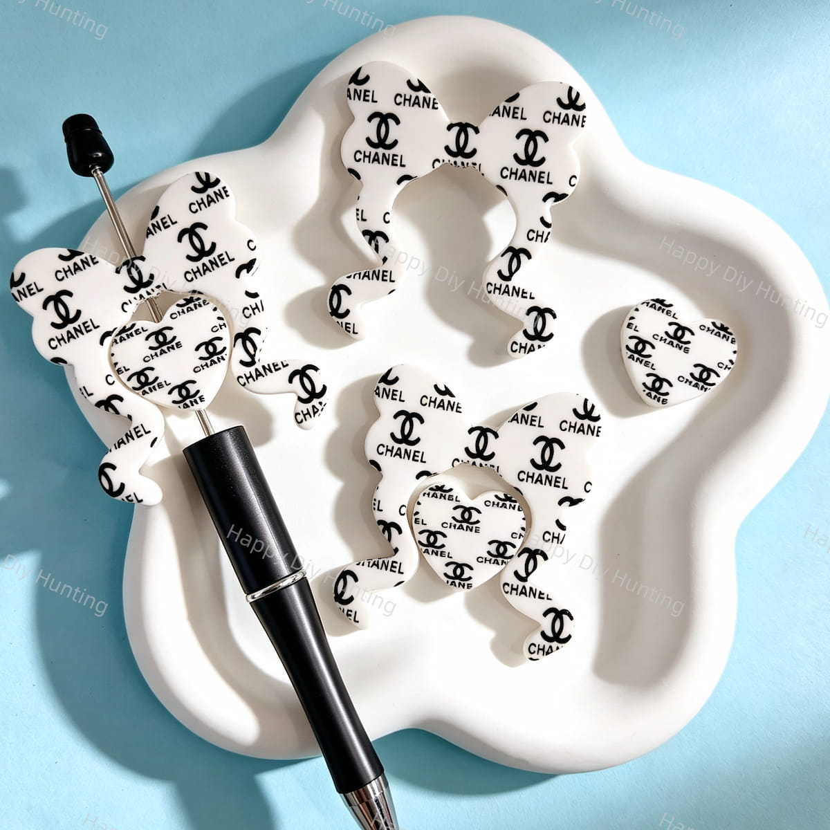 Bow-shaped silicone focal beads featuring a white and black CC print design. Soft, durable, and flexible, perfect for beadable pens, keychains, and handmade crafts.