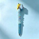 Sample display beadable pen decorated with Alice In Wonderland themed no‑hole pen toppers and assorted beads