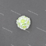 A small white and light green artificial flower craft embellishment, photographed from above on a dark gray textured background with repeating 'Happy DIY Hunting' watermarks.