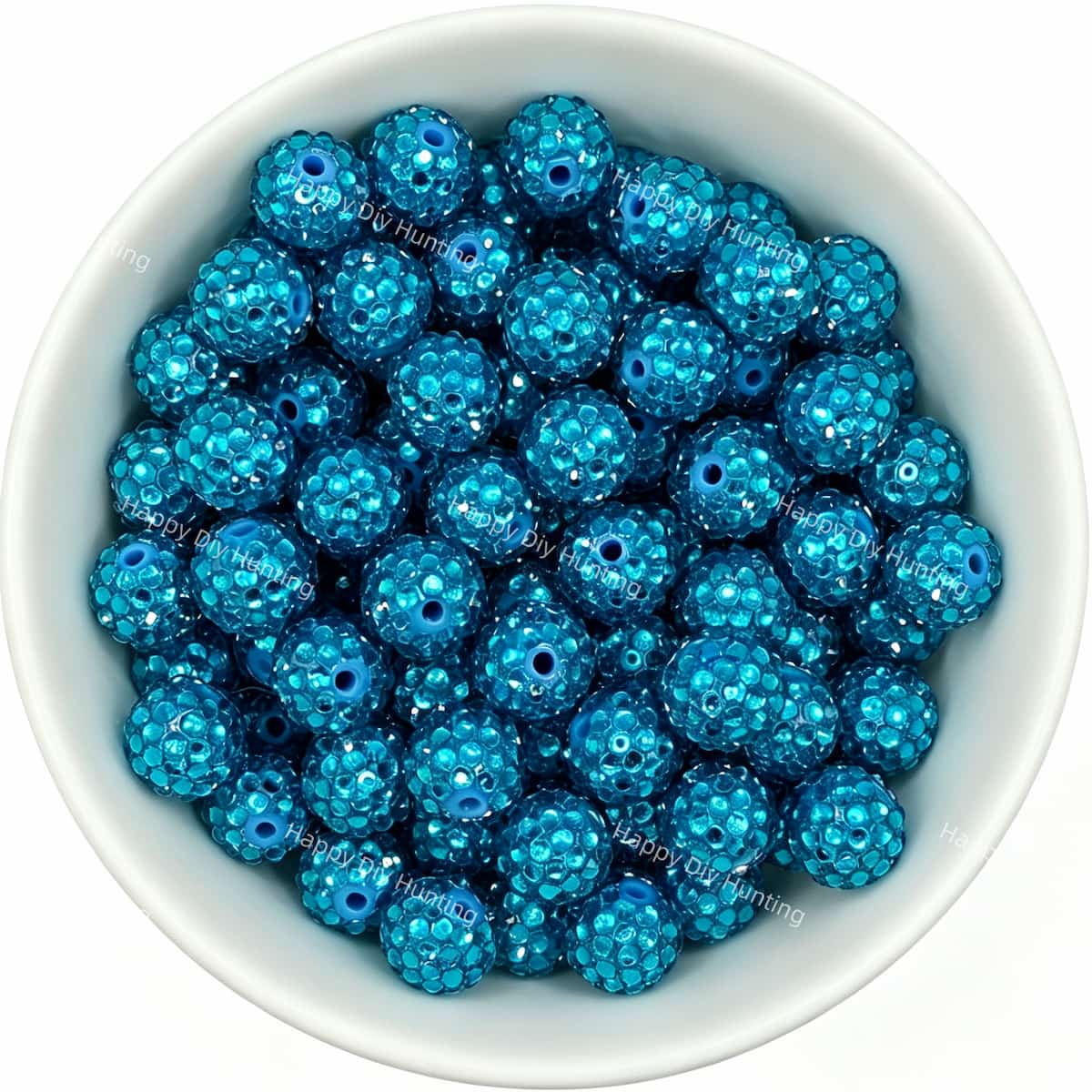 Cyan rhinestone beads in matte white bowl, white background, top‑down view, high‑resolution product photo