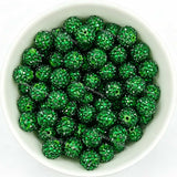 Dark green rhinestone beads in matte white bowl, white background, top‑down view, high‑resolution product photo