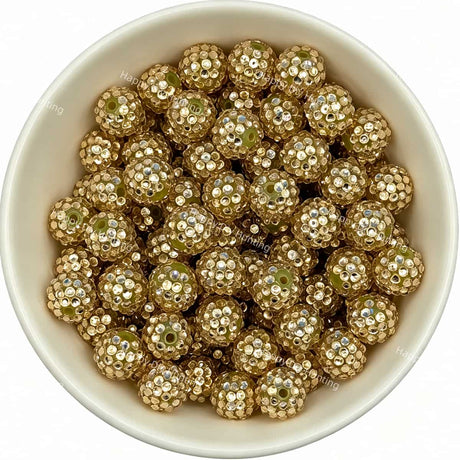 Gold rhinestone beads in matte white bowl, white background, top‑down view, high‑resolution product photo