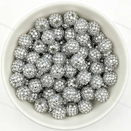 Silver rhinestone beads in matte white bowl, white background, top‑down view, high‑resolution product photo