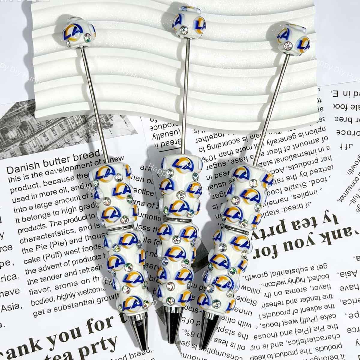 close-up blue yellow ring letter LA*R football beadable pen showing letter design and beadable barrel