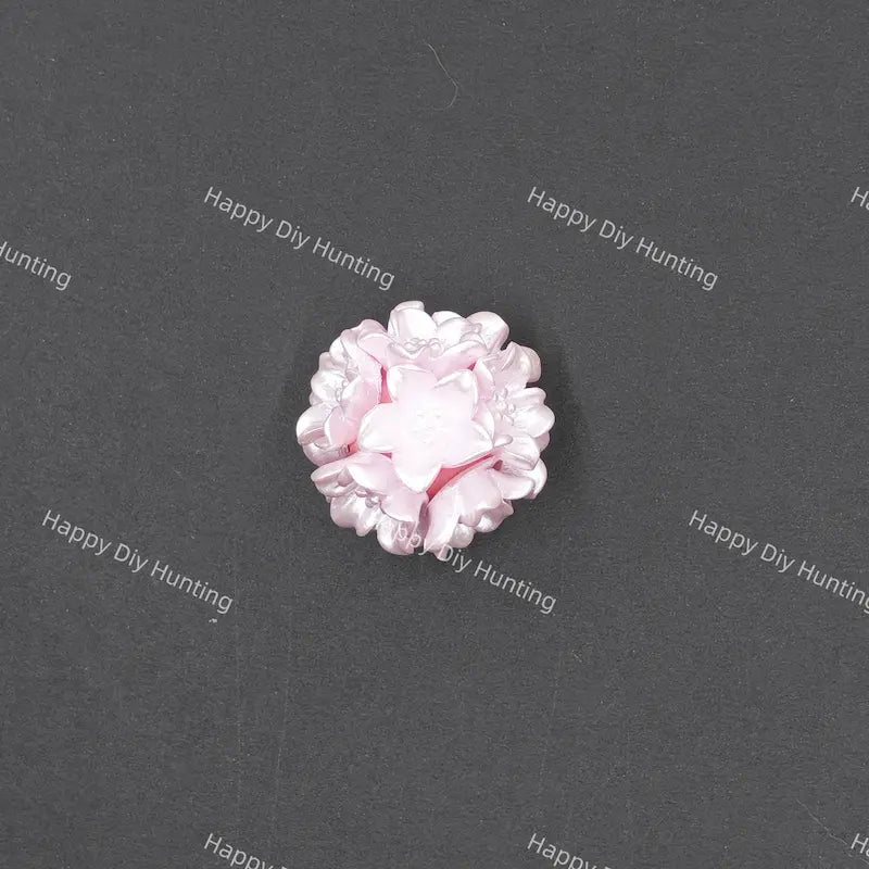 A single light pink flower-shaped craft bead with layered petals, shown on a dark gray textured background with repeating 'Happy Diy Hunting' watermarks.