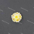 A small white and yellow flower-shaped bead or charm with orange-red speckles, centered on a dark gray background with repeated 'Happy DIY Hunting' watermark text.
