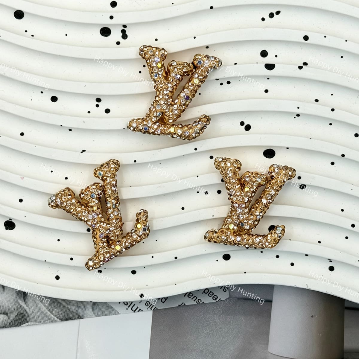 Metallic gold with AB iridescent rhinestone LV charm for luxury‑style DIY craft supplies.