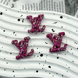 Vibrant magenta with AB iridescent rhinestone LV charm for handmade craft projects.