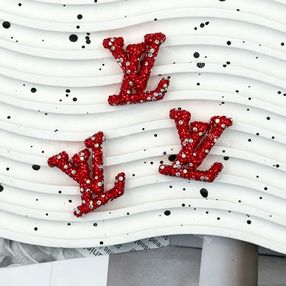 Red base with white crystal rhinestone LV charm for handmade stationery and hair accessories.