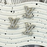 Silver tone AB iridescent rhinestone LV charm for handmade jewelry and cream glue projects.