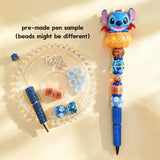Pre-made beaded pen featuring a blue cartoon monster character sitting inside an orange Halloween pumpkin topper, decorated with blue rhinestone beads and pumpkin charms.