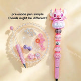 Pre-made beaded pen featuring a cute pink cartoon alien monster emerging from a pink Halloween pumpkin topper, styled with pink glitter beads and skull charms.
