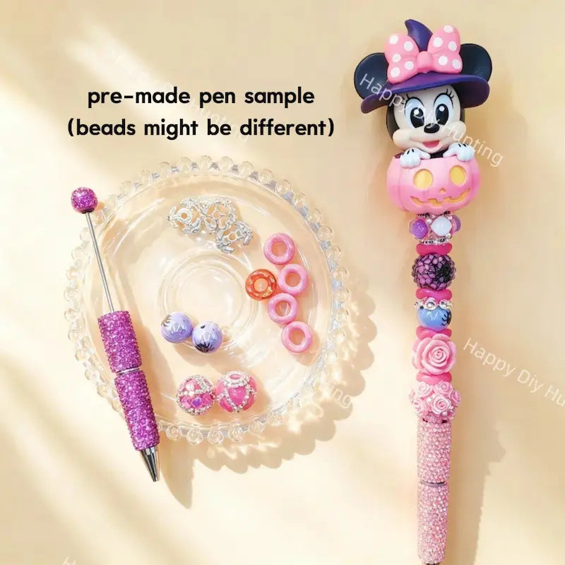 Pre-made beaded pen featuring a cute cartoon girl mouse with a witch hat emerging from a pink Halloween pumpkin topper, styled with pink and purple glitter beads.