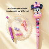Pre-made beaded pen featuring a cute cartoon girl mouse with a witch hat emerging from a pink Halloween pumpkin topper, styled with pink and purple glitter beads.