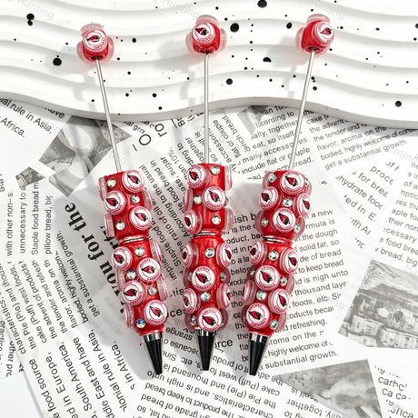 Red bird‑head football emblem sports beadable pens, circular beads printed with red bird‑head patterns and iridescent rhinestones for diy handmade stationery
