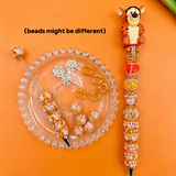 Tigger theme DIY beadable pen crafts with an orange tiger pen topper, patterned focal beads, and sparkling crystal rhinestone details.