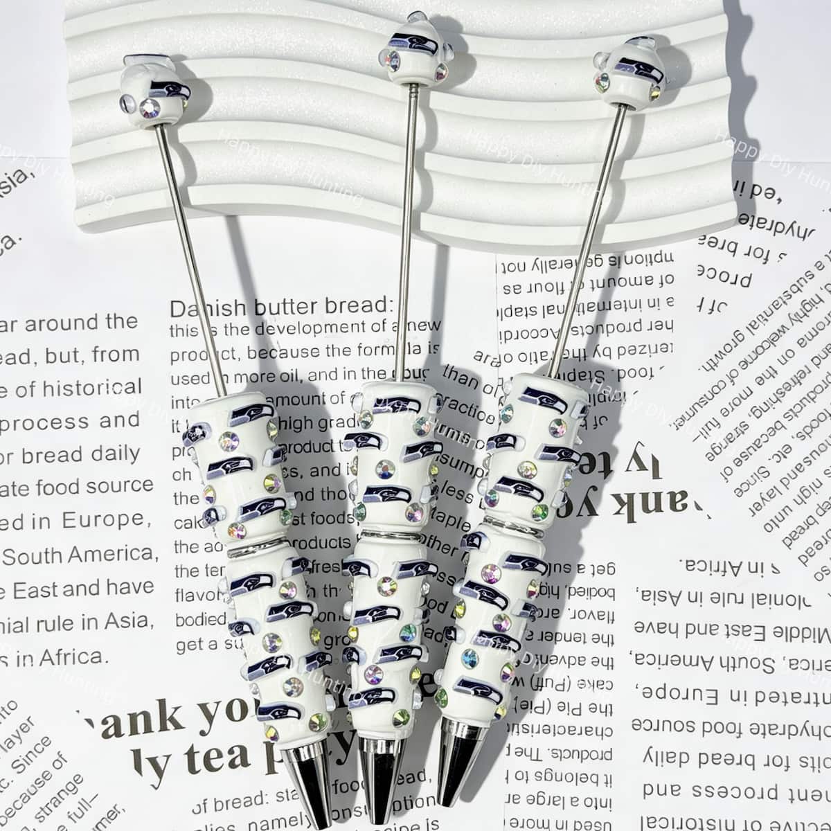 close-up white Seahawk bird SS football beadable pen showing seahawk design and beadable barrel